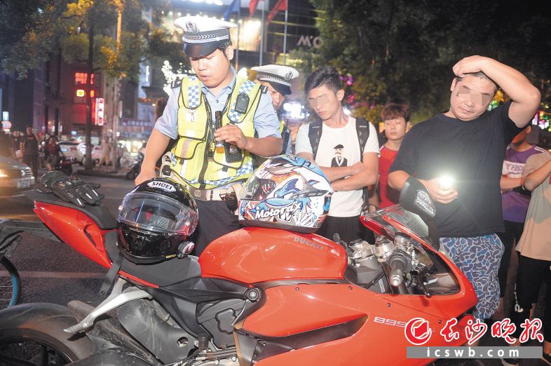 ←民警在解放西路将一辆红色摩托车拦停，检查驾驶人相关证件。长沙晚报记者 余劭劼 摄