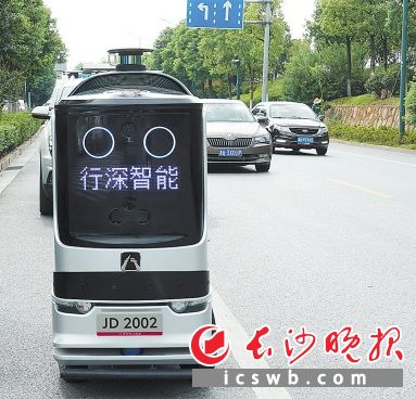 行走在城市马路上的京东配送机器人。
