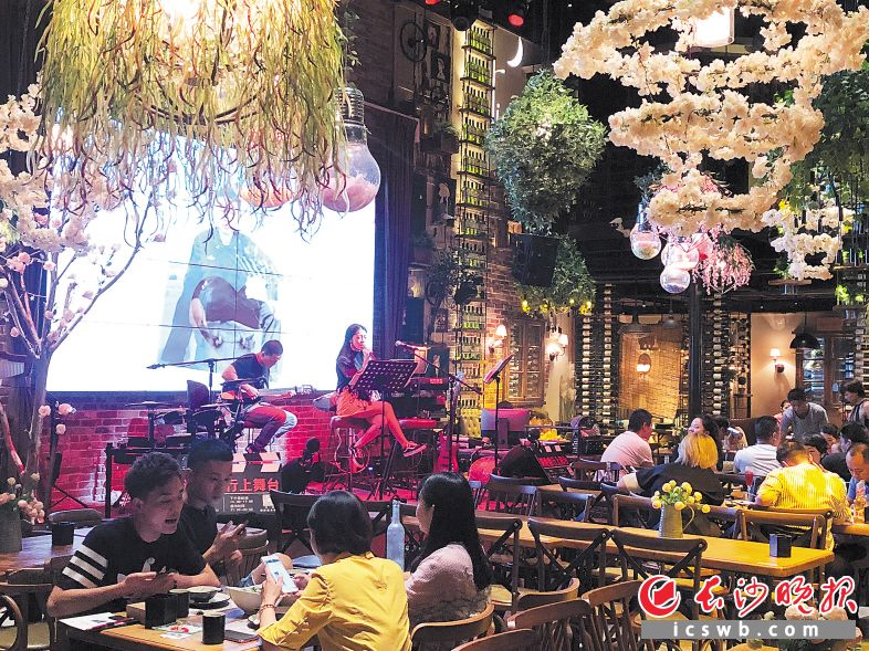 在长沙，越来越多的餐馆签约驻唱歌手，营造美食、美酒、音乐融于一体的氛围。长沙晚报记者 刘琼萍 摄