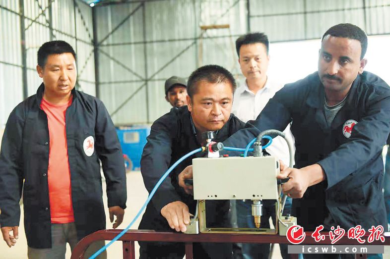 曹军汉在埃塞打拼17年，可以说一口流利的埃塞语。图为他在自己建的摩托车厂指导本地员工生产。 长沙晚报记者 黄启晴摄