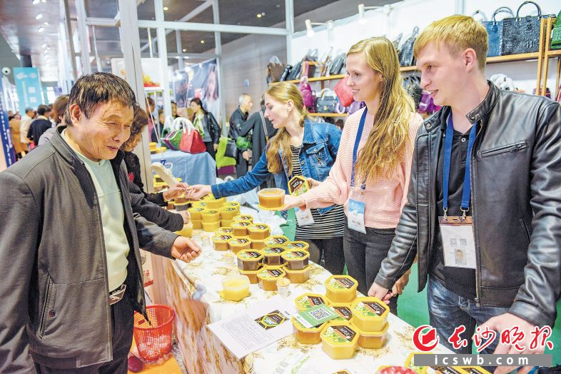 第十六届农交会暨第二十届农博会上，俄罗斯帅哥美女在向观展者推销当地产的蜂蜜。 长沙晚报记者 陈飞 摄