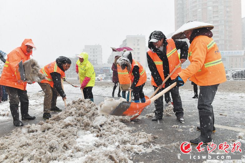 2018年12月30日11时许,车站北路和三一大道交会处附近,环卫工人和社区工作人员清扫路面积雪保畅通。 王志伟 摄