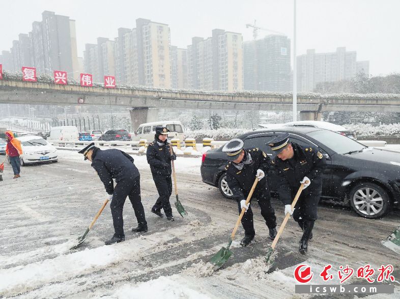 大雪中,天心区城管执法大队队员们在湘府路大桥上铲除积雪,为路面保畅。天心区城管执法局供图