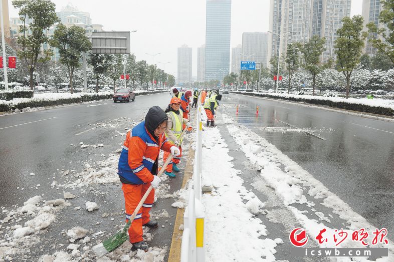 金星北路上环卫工人正在加紧清理路面积雪确保路面畅通。余劭劼 摄