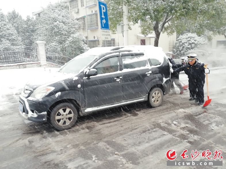 岳麓区城管执法队员在帮助市民打滑的车辆上坡。岳麓区城管执法局供图