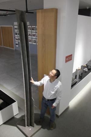 铂力特公司副总经理杨东辉展示采用具有自主知识产权的“金属3D打印”技术和设备,打印出的C919中央翼缘条。李晨/摄