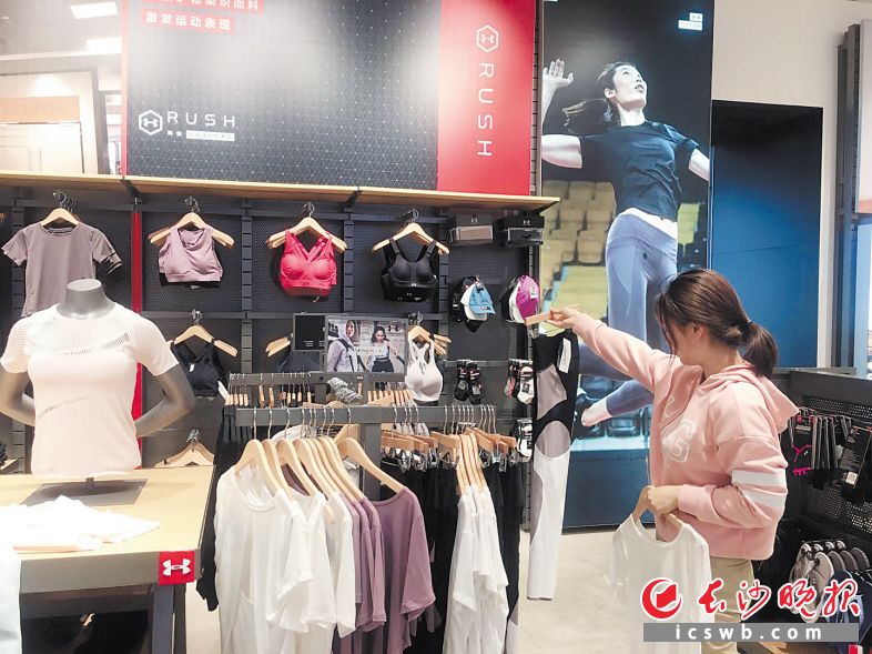 图为健身爱好者在精心挑选时尚运动装备。 长沙晚报全媒体记者 周丛笑 摄