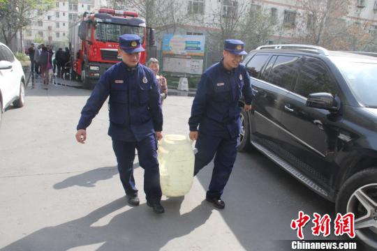 消防人员为老人送水。 徐嘉奇 摄