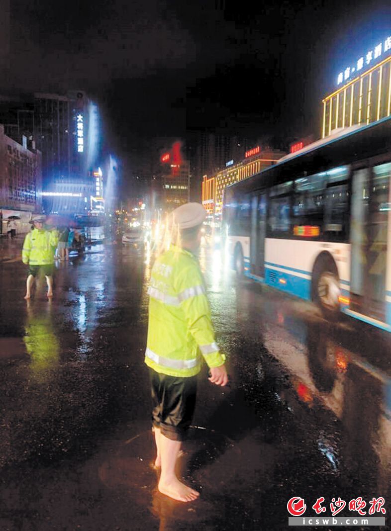 21日，长沙突遇暴雨，长沙交警坚守岗位，在雨中维护交通秩序。长沙交警供图