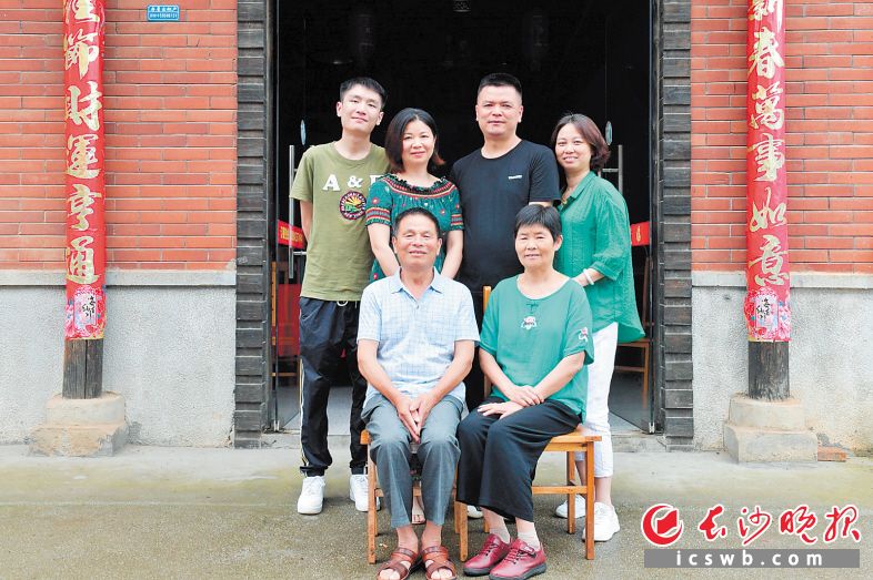 冯术炎（前排左一）和家人在儿子开的饭店前开心合影。长沙晚报全媒体记者 王志伟 摄