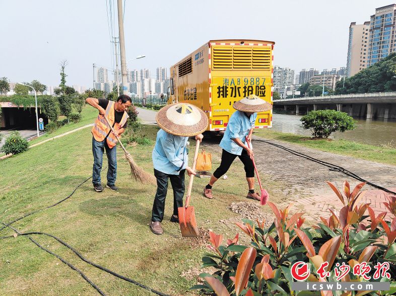 工作人员正清扫护坡上的淤泥和垃圾。长沙晚报通讯员 唐海霞 摄