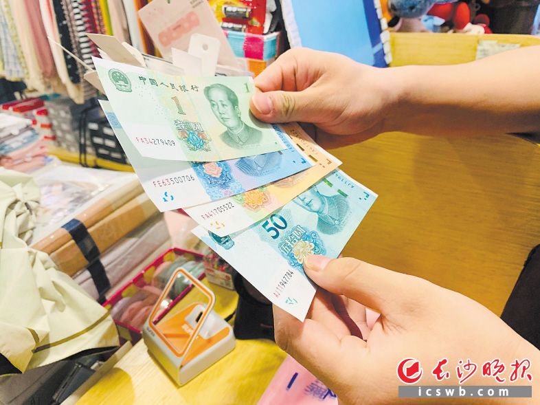 9月5日上午，记者拿着新版人民币购物，商店收银员仔细鉴别。长沙晚报全媒体记者 刘琼萍 实习生 皮景婷 胡自含 摄影报道