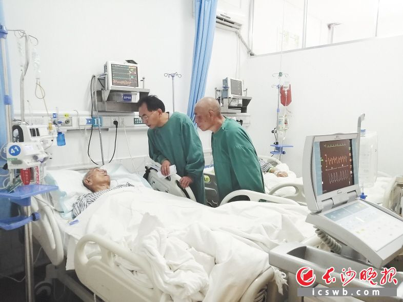 王大庆（中）探望躺在病床上的父亲。长沙晚报通讯员 李小雷 摄