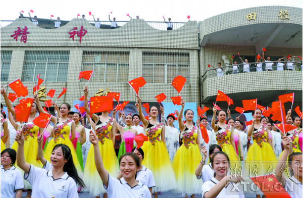 市二中师生在今年秋季开学典礼暨庆祝第35个教师节活动上，挥舞着五星红旗，共同唱响《我和我的祖国》。（记者 胡美玲 摄）