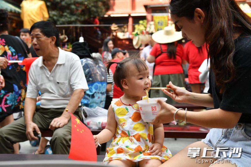 2岁的成都小游客也爱上了“国庆面”，妈妈说：“有幸福的味道。”