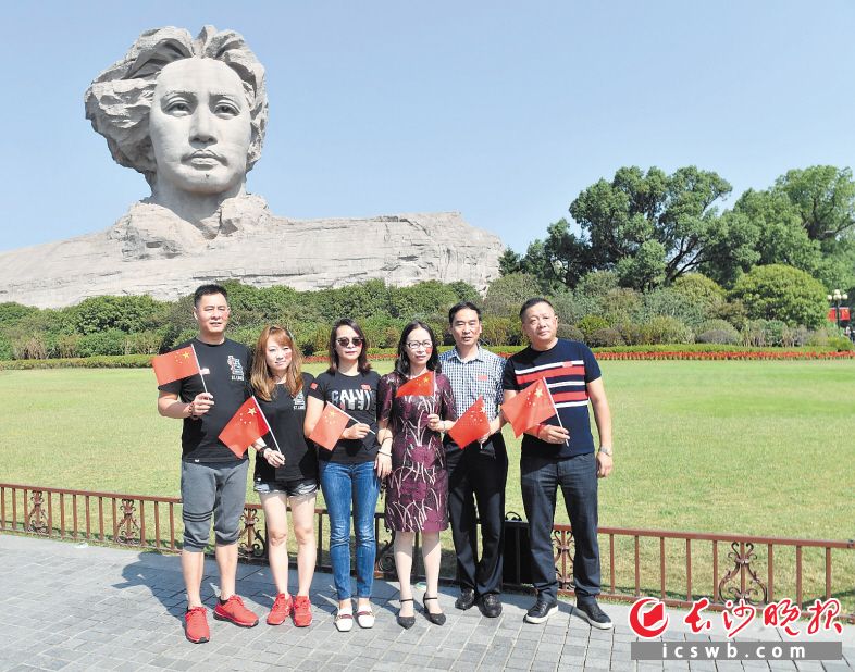 ↑10月2日，游客手持国旗在橘子洲青年毛泽东雕像前合影留念。均为长沙晚报全媒体记者 余劭劼 摄