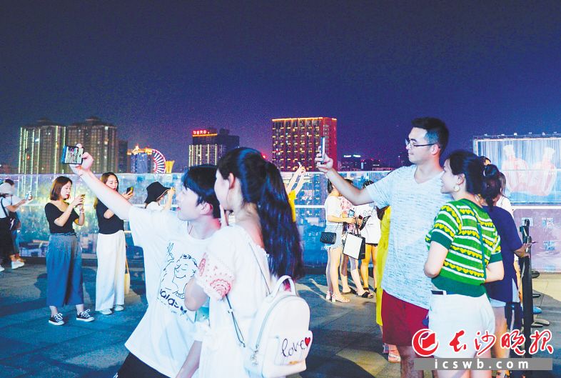 ↑在长沙国金中心7楼平台,游客们正在拍照。