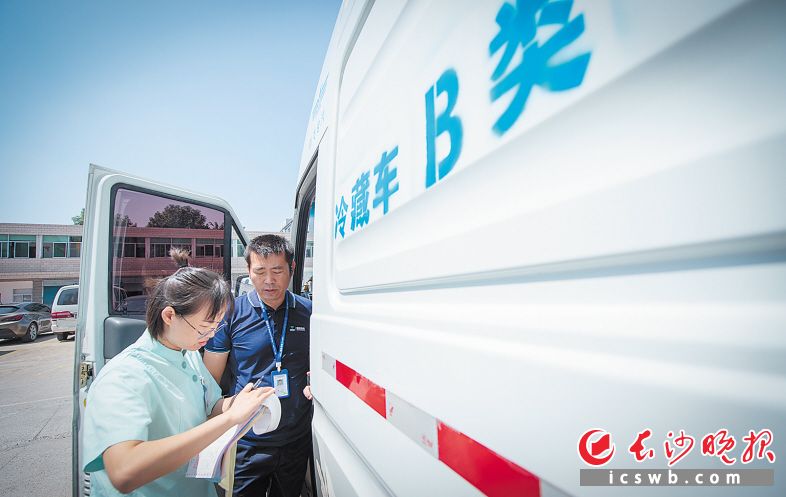9月19日11时45分 地点:长沙县星沙街道社区卫生服务中心 收货前,接种门诊工作人员查看冷藏车内疫苗的保存温度。