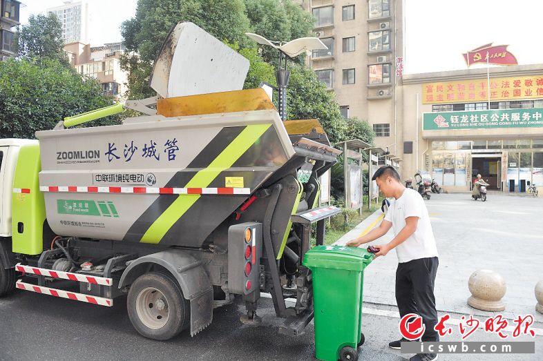 ←钰龙天下小区，岳麓区环卫部门收运车将小区内专用收集桶中的湿垃圾通过液压装置倾倒至密封车厢内。均为余劭劼 摄