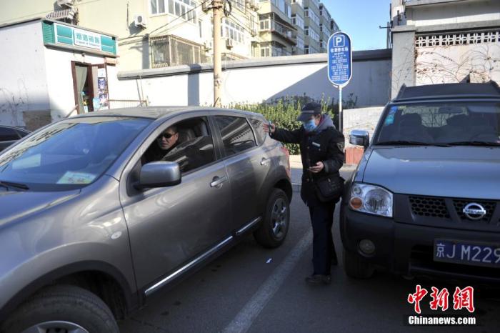 北京市某泊车场治理员为车主批示倒车。中新网记者 金硕 摄