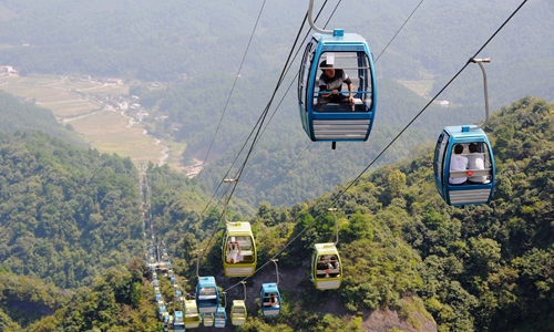 9月27日,新宁县崀山八角寨索道建成运行,游客乘缆车观赏美景.