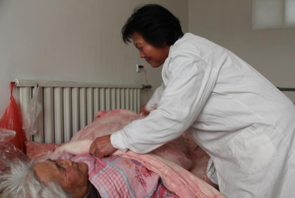 瘫痪在床的老人是王君花重点照顾的对象,她会定时给他们按摩.
