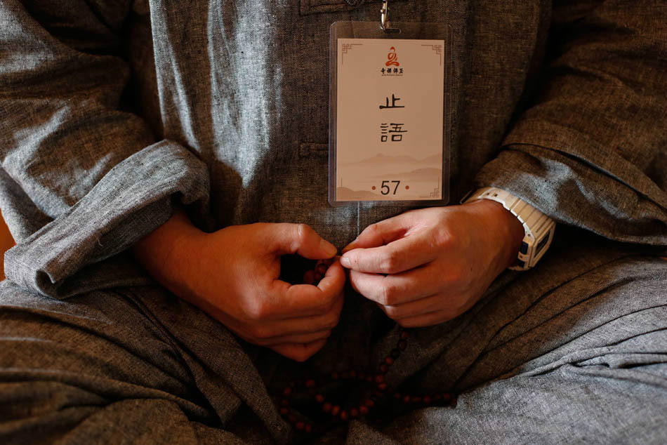 一位学员的胸前挂著"止语"的牌子.