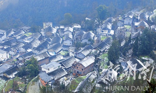 12月20日,湘西自治州花垣县排碧乡双龙村,农家屋顶上覆盖了白雪