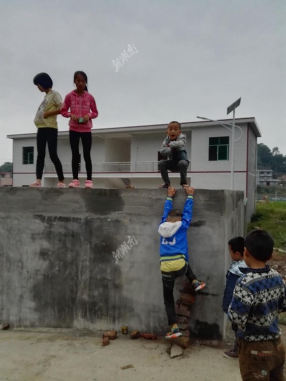 10月1日,涟源市桥头河镇彦溪村,小朋友们在爬墙玩耍.