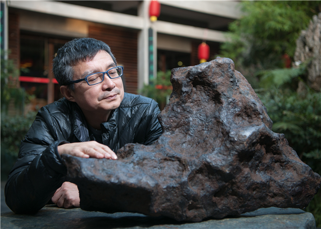 轻轻抚着一块瑞典m铁陨石,柯作楷沉醉在星星的世界.