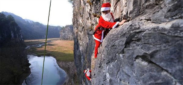 湄江“圣诞老人”爬百米悬崖挂圣诞树