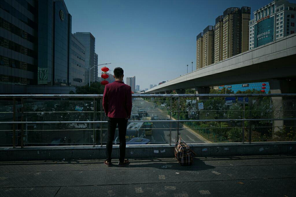 深圳龙岗双龙地铁站天桥上,一位即将离开深圳年轻人的背影卢七星 摄