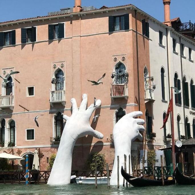 艺术家在威尼斯河道上创造巨手雕塑 警示气候变化