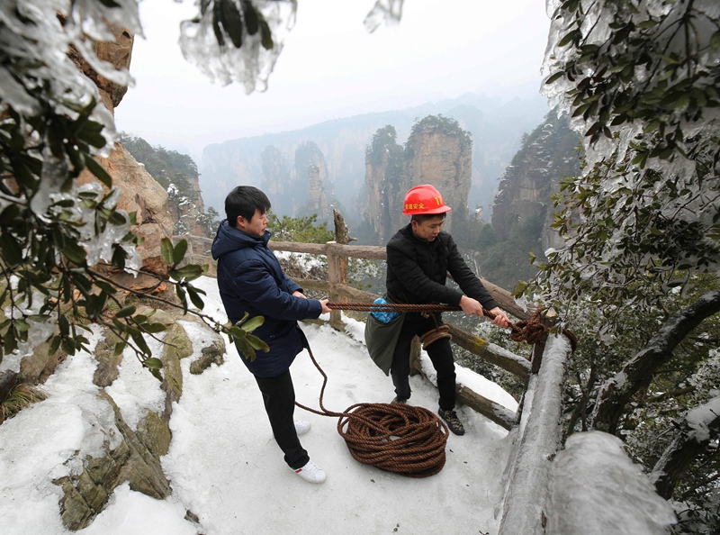 张家界黄石寨景区冰雪下的悬崖清洁工