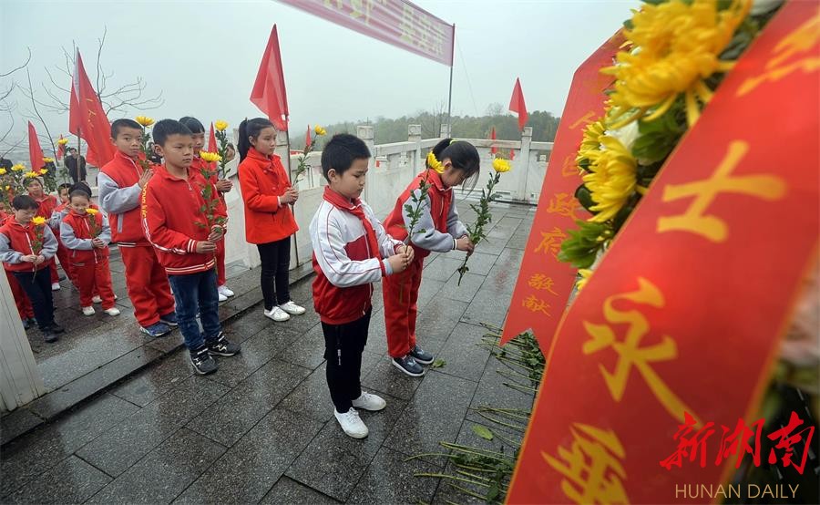 3月27日,东安县金鸡岭革命烈士陵园,学生向革命烈士纪念碑献花.