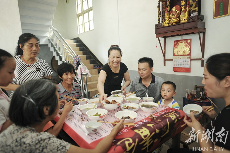 7月11日中午,衡东县新塘镇石杨村8组,曹小珍(右四)给受灾的居民端