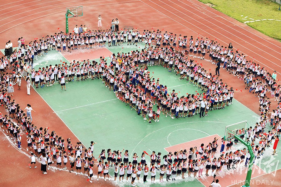 9月2日上午,长沙市开福区浏阳河小学,师生排成"70"字样的队形,一起