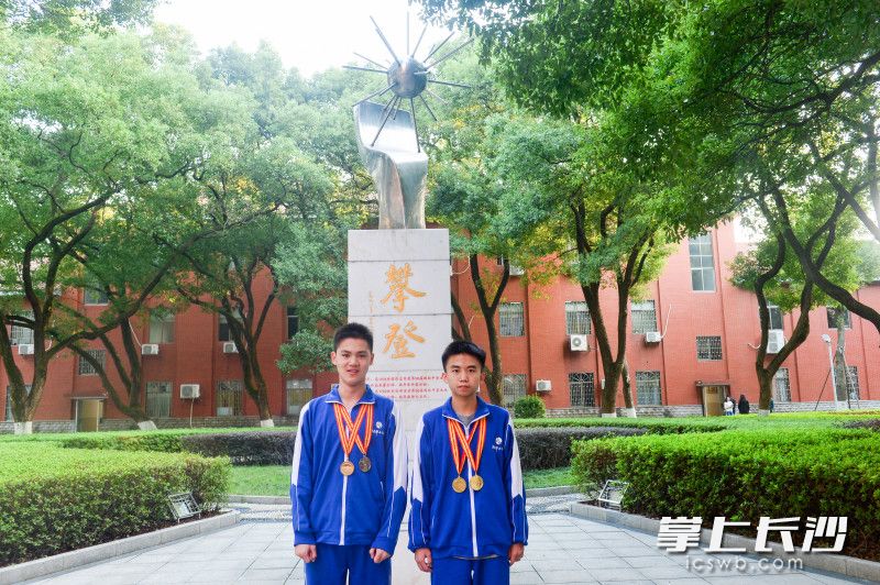 载誉归来的谢荣靖（右）和同学在湖南师大附中攀登碑前留念。长沙晚报通讯员 苏晓玲 摄